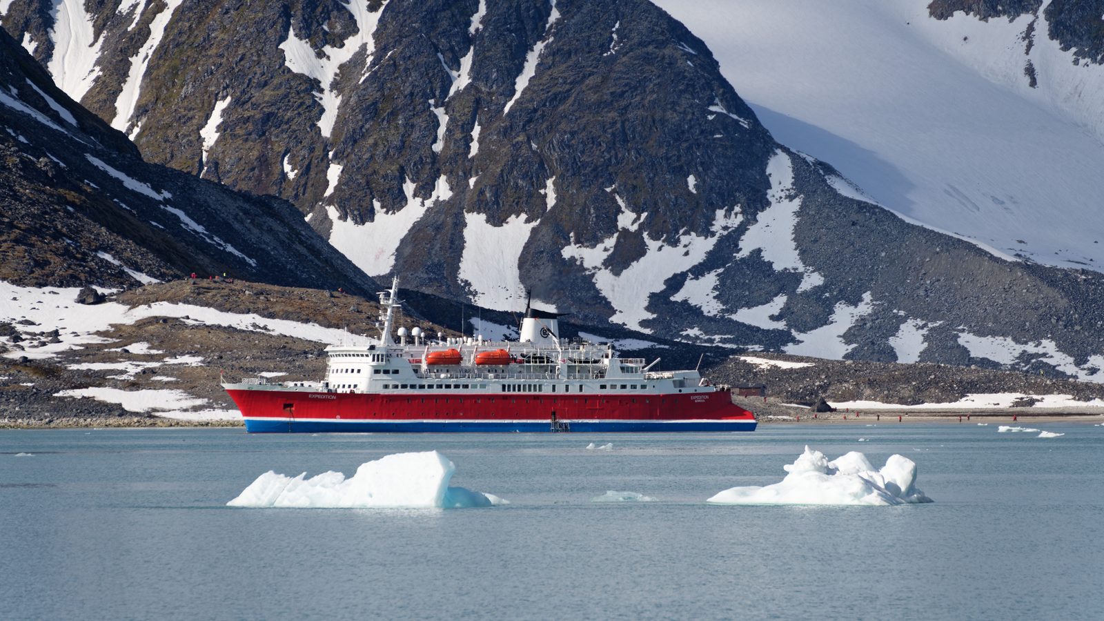 A red expedition ship among icebergs in Antarctica
